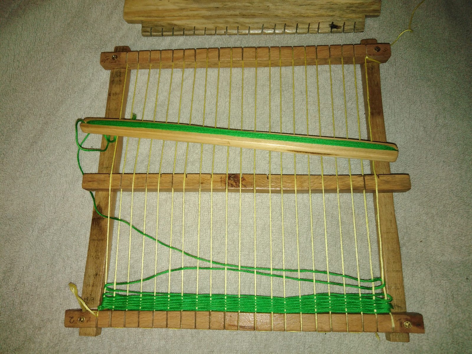 Ξύλινος αργαλειός για παιδιά με πολύχρωμα νήματα και απλό σχεδιασμό.